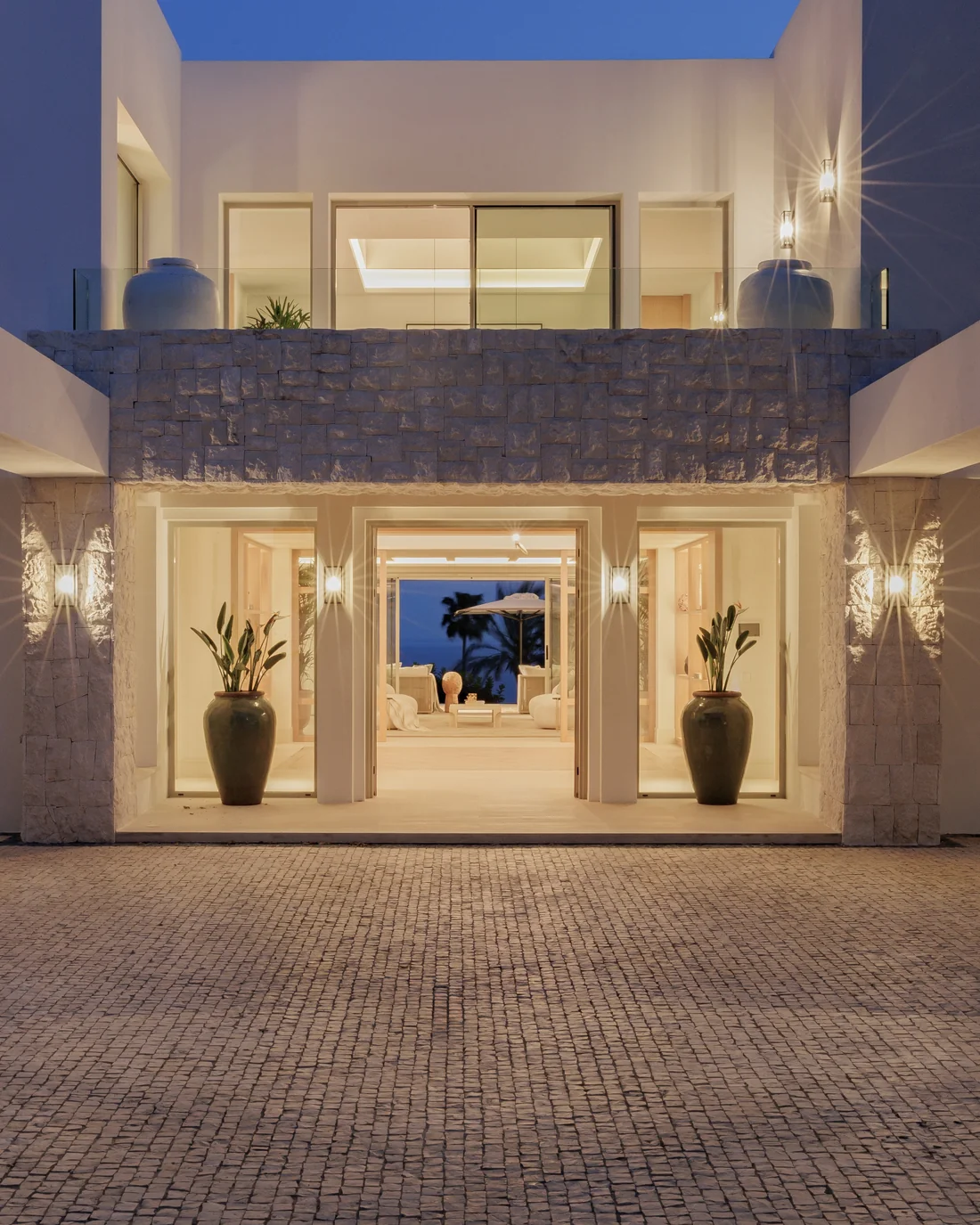 Entrada de Villa Altos Reales en Marbella iluminada de noche, construida por Muñoz Lanzas Construcción