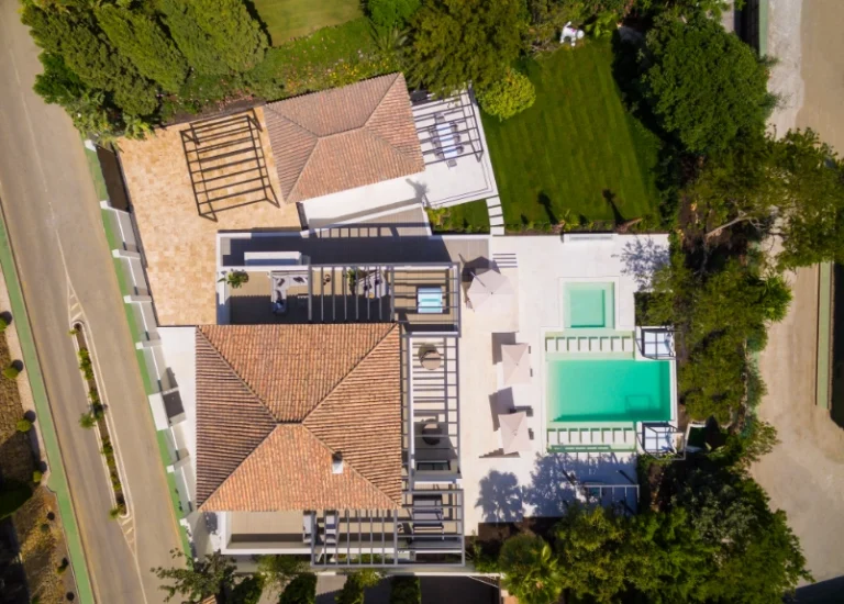 Vista aérea de una villa con cubiertas de teja y piscina
