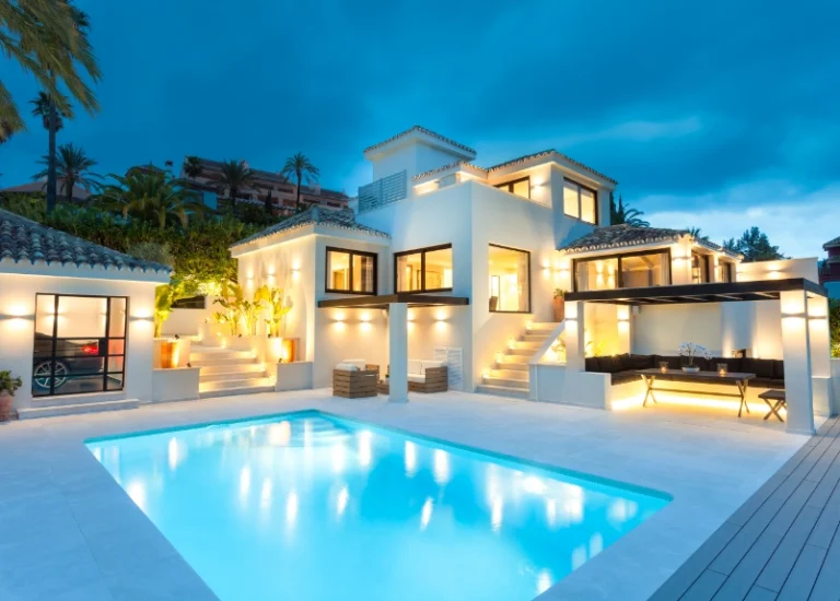 Villa contemporánea con piscina iluminada al anochecer