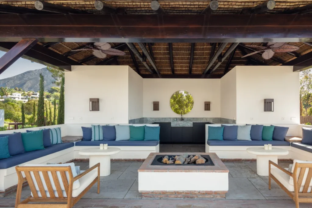 Covered outdoor lounge with a fireplace at Villa Gratitude