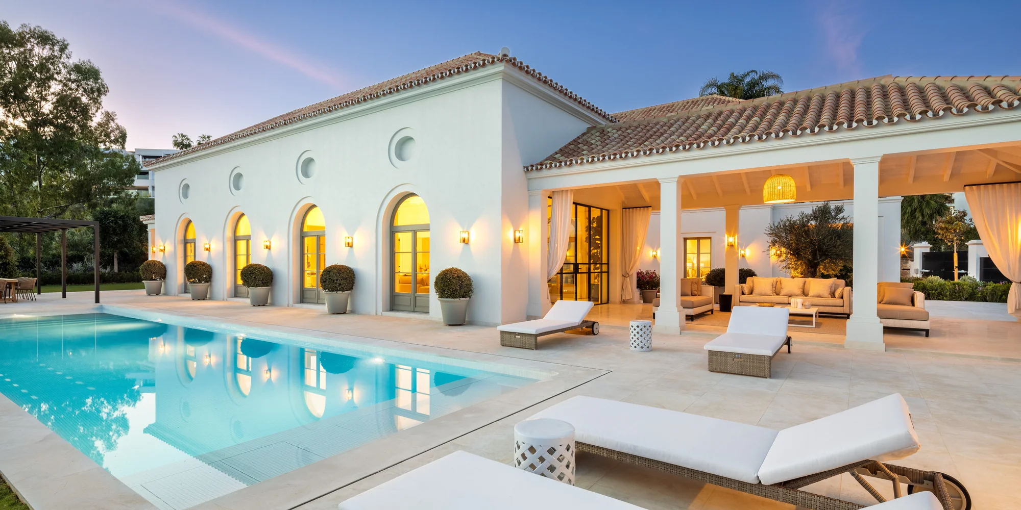 Villa Pleyades 10 in Nueva Andalucía, Marbella: pool and arched façade lit up at dusk