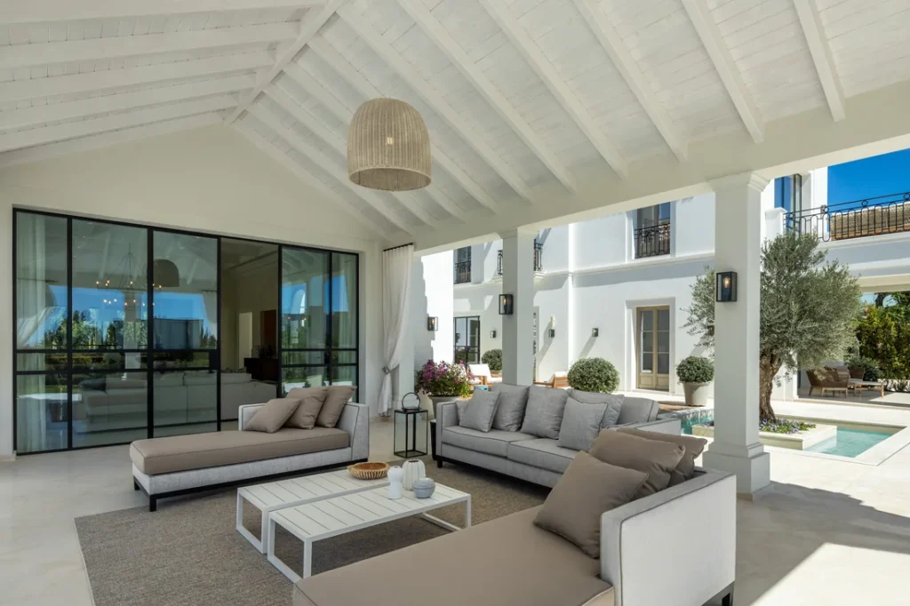 Covered terrace with an outdoor lounge opening onto the garden at Villa Pleyades 10