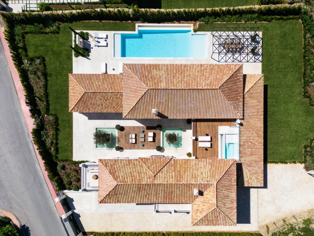 Overhead view of Villa Pleyades 10 with tiled roofs, pool and garden
