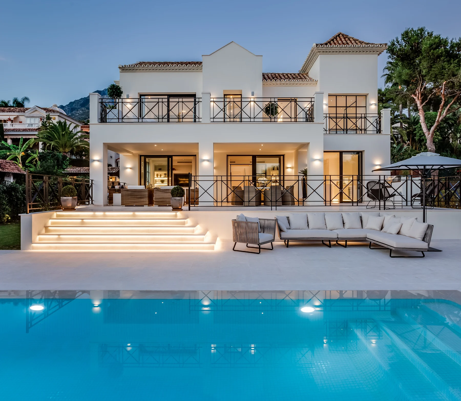 White two-storey Mediterranean villa with stepped terraces and pool