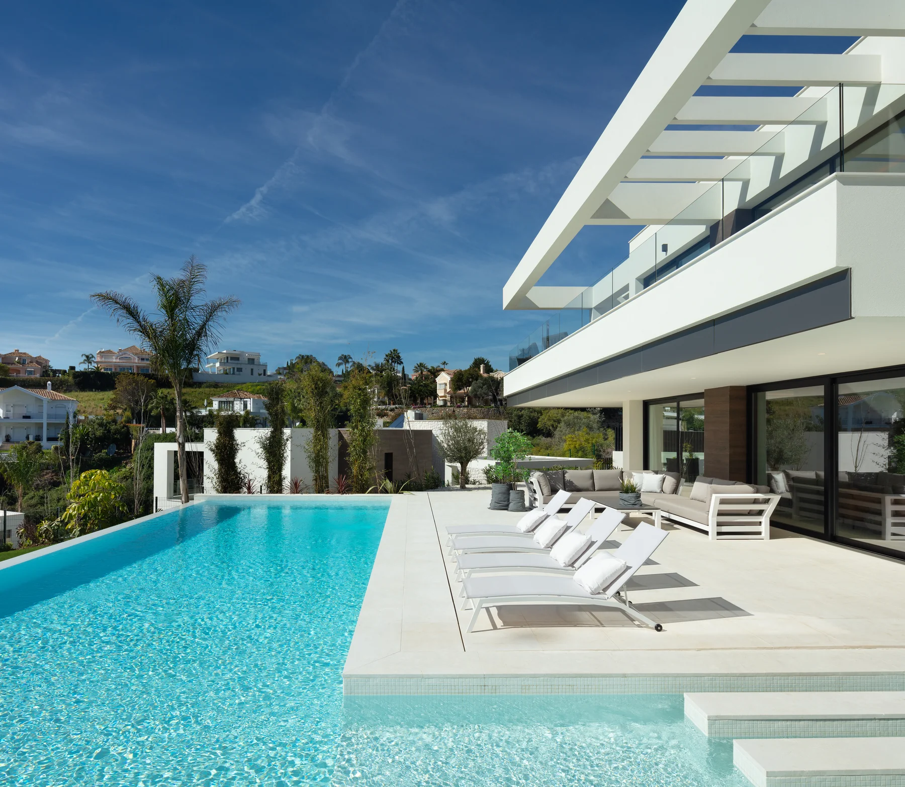 Contemporary villa with infinity pool and sun loungers beside the terrace
