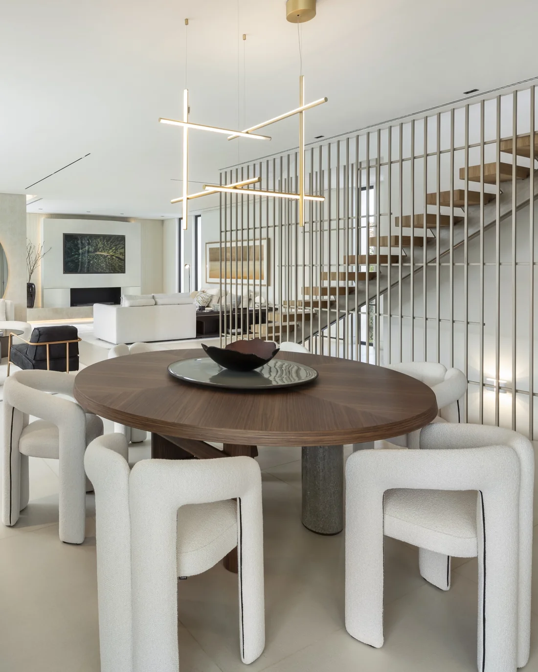 Interior de una vivienda unifamiliar con escalera volada, comedor y salón de doble altura