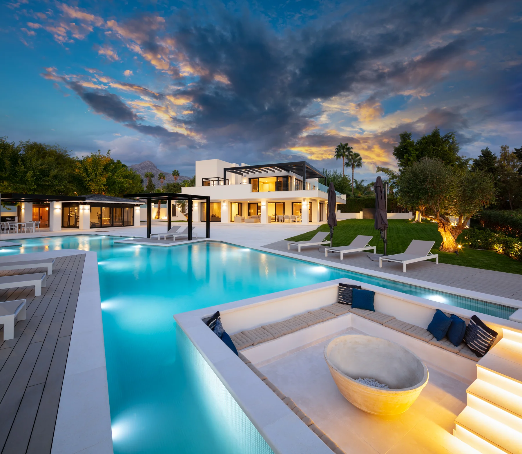 Vivienda unifamiliar de lujo con piscina, pérgolas y jardín al anochecer