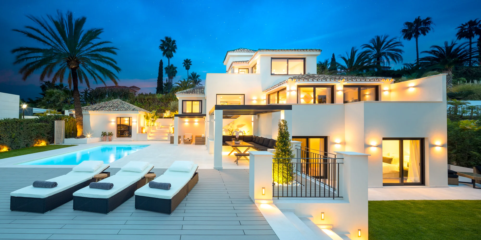 Hill Club 28 en Marbella: villa blanca y piscina iluminadas al anochecer