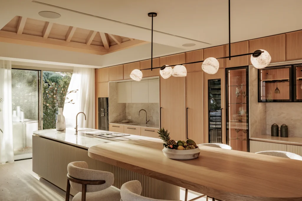 Villa Altos Reales, cocina con isla de piedra y frentes de madera