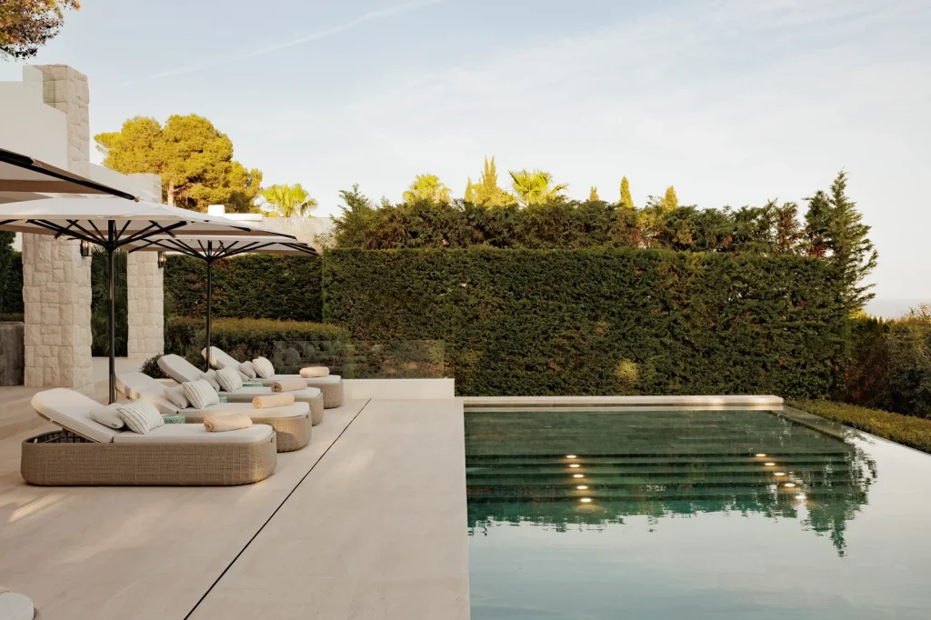 Villa Altos Reales, terraza con tumbonas, sombrillas y piscina infinita