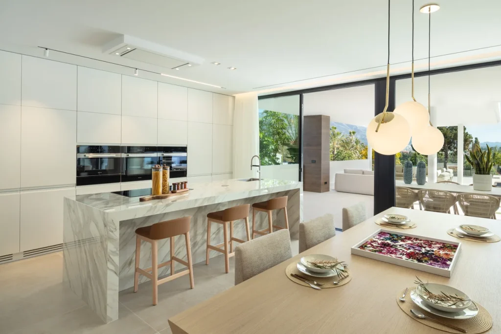 Cocina con isla de mármol y comedor en Villa Brisas