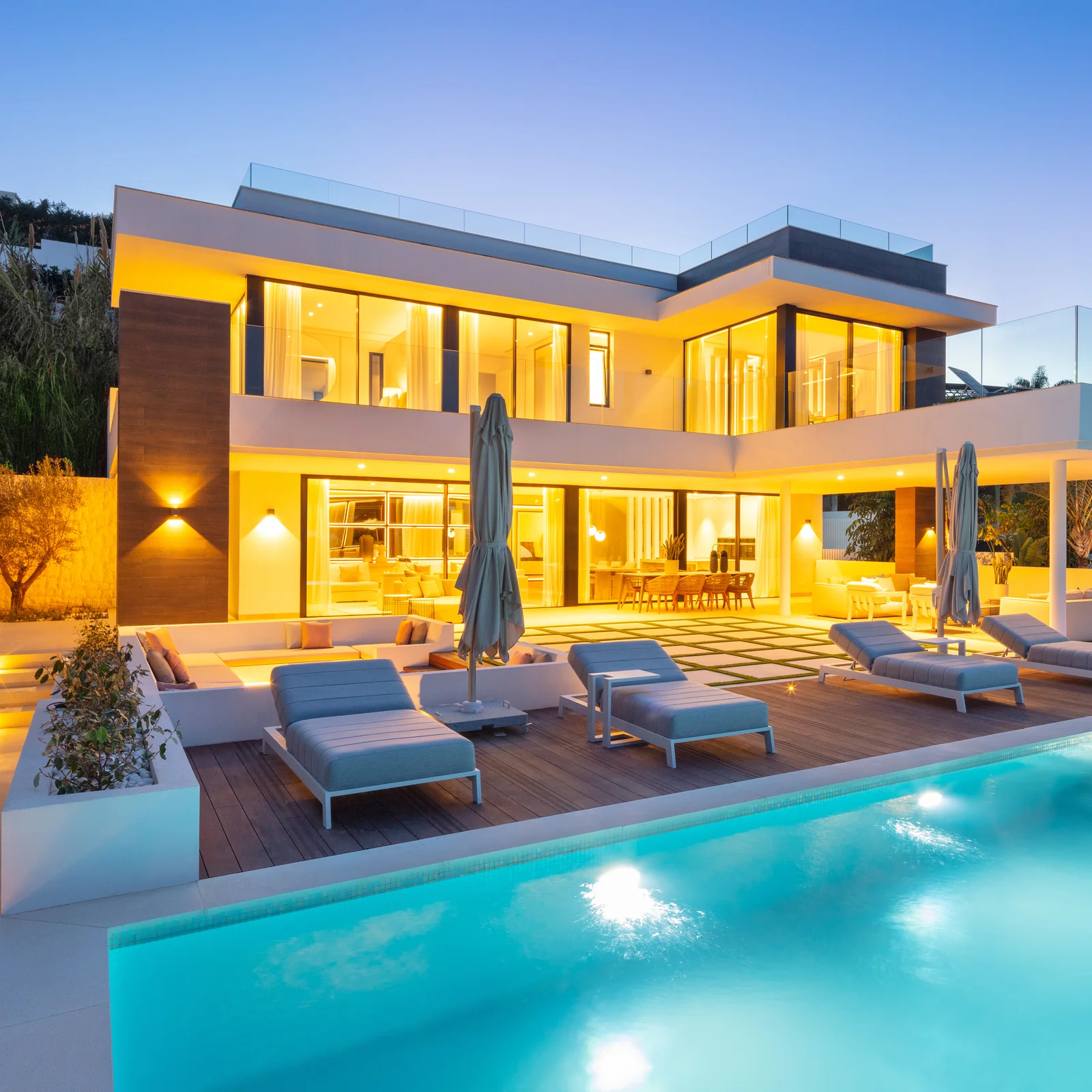 Fachada de Villa Brisas y piscina iluminadas al anochecer