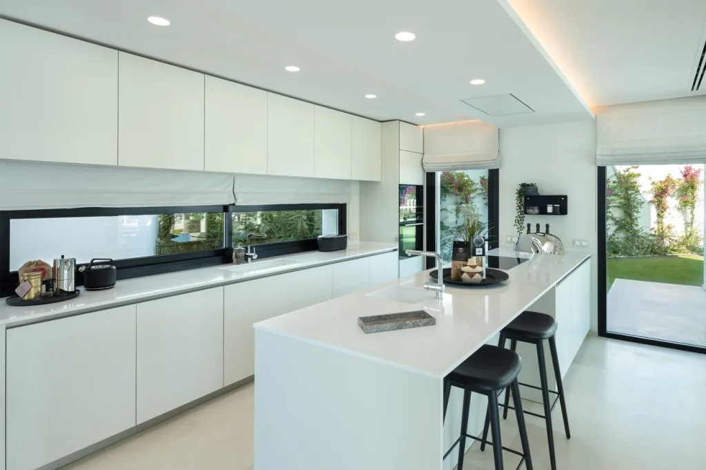 White kitchen with an island at Villa Cerquilla 21 B