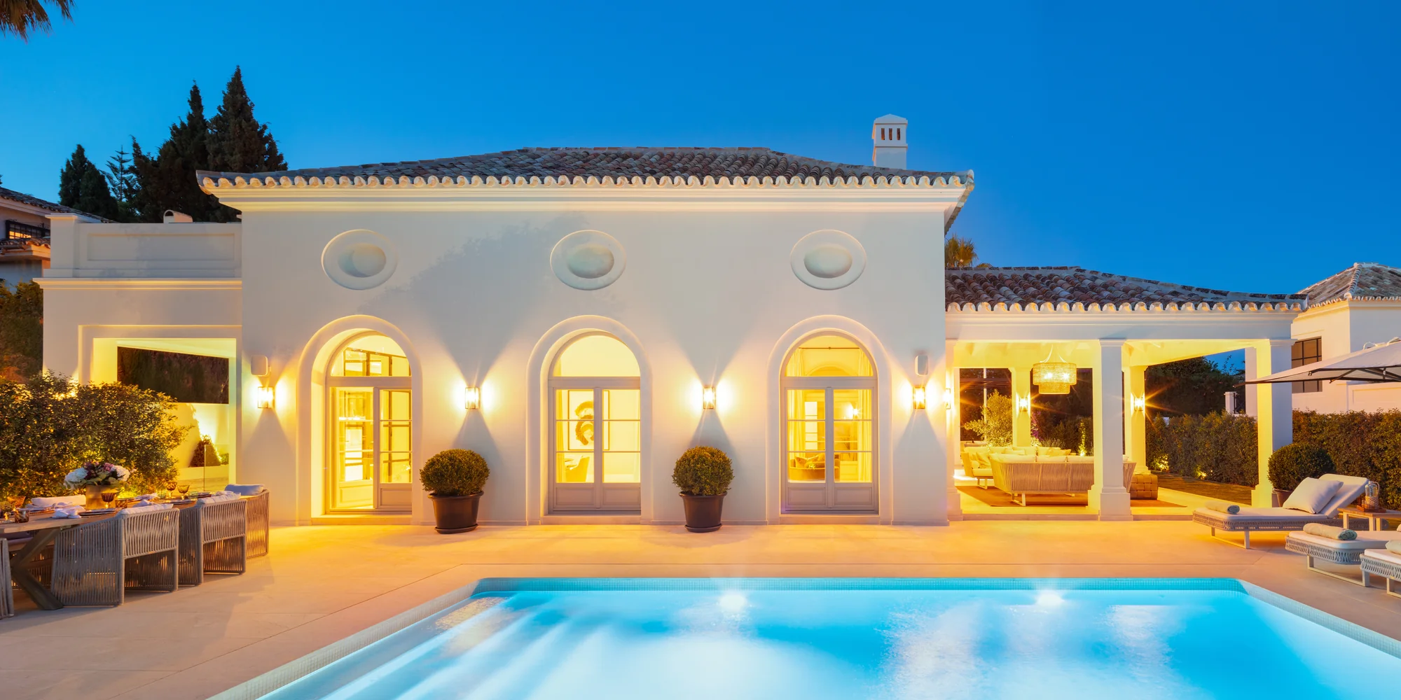 Villa Nagueles en Marbella: piscina y fachada andaluza al anochecer